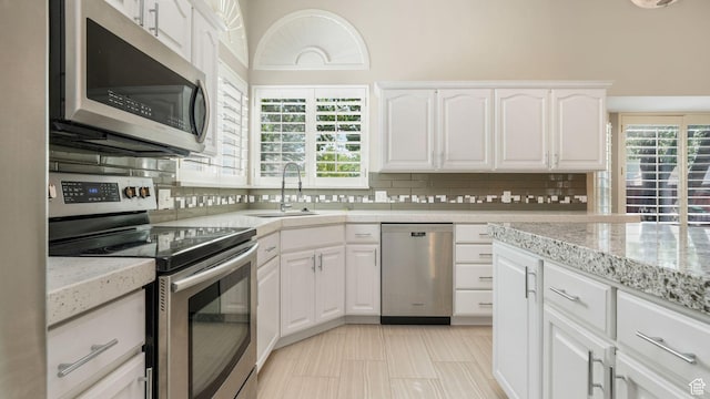6320 S Hathaway St, Taylorsville, UT 84123 - kitchen with stainless steel appliances, decorative backsplash, white cabinets, and light stone countertops