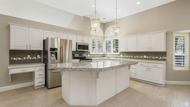 6320 S Hathaway St, Taylorsville, UT 84123 - kitchen featuring stainless steel appliances, white cabinetry, backsplash, a center island, and a high ceiling