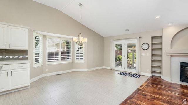 6320 S Hathaway St, Taylorsville, UT 84123 - unfurnished living room with a chandelier, a fireplace, vaulted ceiling, and recessed lighting
