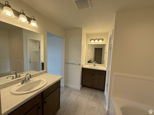 6921 W S Jordan Pkwy Unit 310, South Jordan, UT 84009 - full bathroom featuring vanity, a garden tub, a stall shower, and a textured ceiling