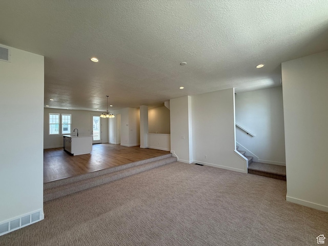 6921 W S Jordan Pkwy Unit 310, South Jordan, UT 84009 - spare room with carpet, recessed lighting, a chandelier, stairway, and a textured ceiling
