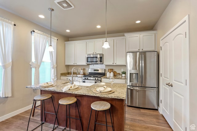 10572 S Kestrel Rise Rd, South Jordan, UT 84009 - kitchen with stainless steel appliances, a breakfast bar, white cabinetry, and recessed lighting
