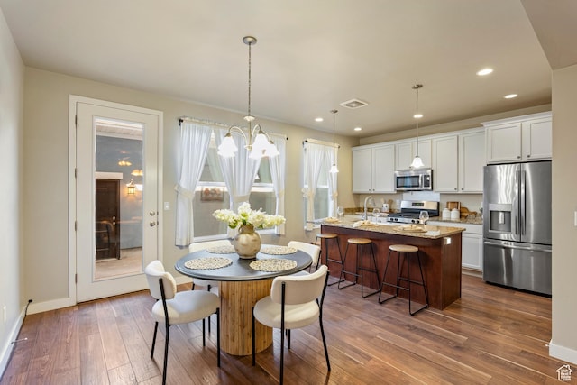 10572 S Kestrel Rise Rd, South Jordan, UT 84009 - dining room with dark wood finished floors, a chandelier, and recessed lighting