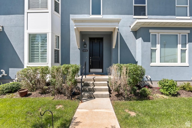 10572 S Kestrel Rise Rd, South Jordan, UT 84009 - view of exterior entry with stucco siding and a yard