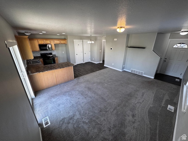 2061 Revere Way, Eagle Mountain, UT 84005 - kitchen featuring black appliances, dark countertops, a peninsula, dark colored carpet, and a chandelier