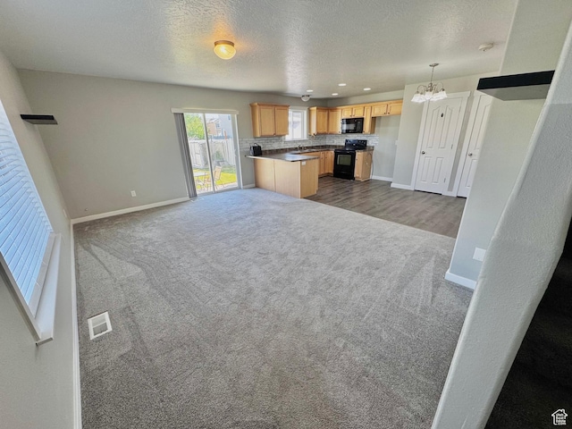 2061 Revere Way, Eagle Mountain, UT 84005 - kitchen with open floor plan, dark carpet, black appliances, a chandelier, and tasteful backsplash