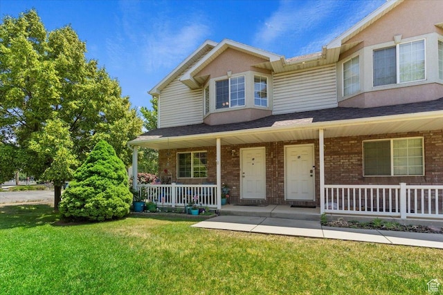 801 W Harrisville Rd N Unit 14, Ogden, UT 84404 - townhome / multi-family property featuring covered porch, a front yard, and brick siding