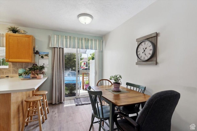 801 W Harrisville Rd N Unit 14, Ogden, UT 84404 - dining area featuring healthy amount of natural light, light wood finished floors, and a textured ceiling