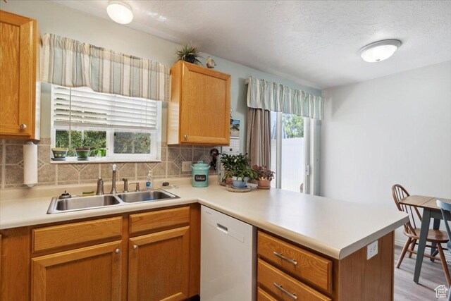 801 W Harrisville Rd N Unit 14, Ogden, UT 84404 - kitchen with dishwasher, a peninsula, tasteful backsplash, light countertops, and a textured ceiling