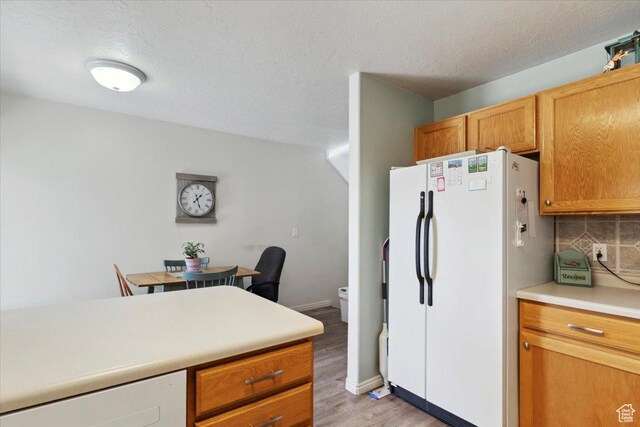 801 W Harrisville Rd N Unit 14, Ogden, UT 84404 - kitchen with freestanding refrigerator, light wood-style floors, light countertops, a textured ceiling, and brown cabinetry