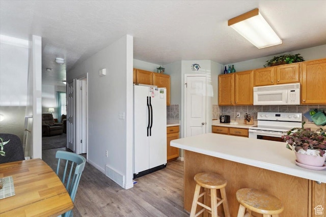 801 W Harrisville Rd N Unit 14, Ogden, UT 84404 - kitchen with white appliances, light wood-style floors, tasteful backsplash, a peninsula, and light countertops