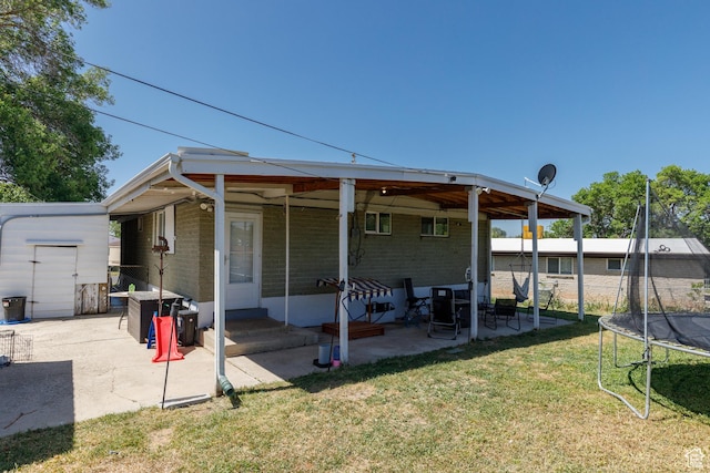 720 E 850 N, Ogden, UT 84404 - rear view of property with a trampoline, a patio area, brick siding, and a lawn
