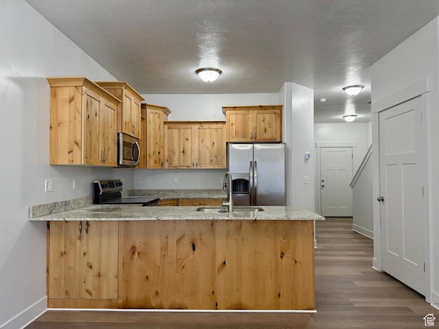 849 N Gleneagles Ct W, Tooele, UT 84074 - kitchen with appliances with stainless steel finishes, a peninsula, dark wood-style flooring, and light stone countertops