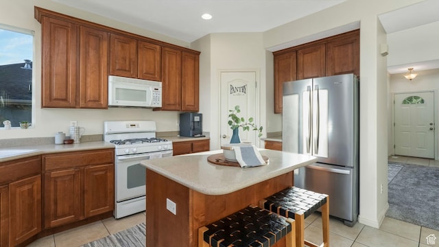 1562 S 910 W, Payson, UT 84651 - kitchen with white appliances, light tile patterned flooring, light countertops, a kitchen breakfast bar, and a center island