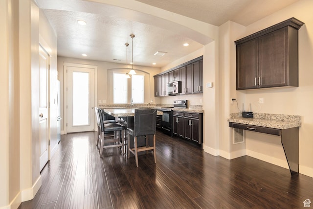 11463 S Lake Run Rd W, South Jordan, UT 84009 - kitchen with black electric range, a breakfast bar, dark brown cabinetry, arched walkways, and a center island