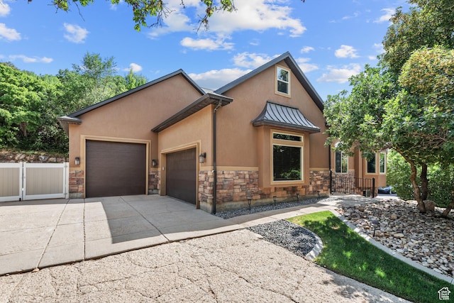 520 Lacey Way N, Salt Lake, UT 84054 - view of front of home featuring stone siding, concrete driveway, stucco siding, an attached garage, and a standing seam roof