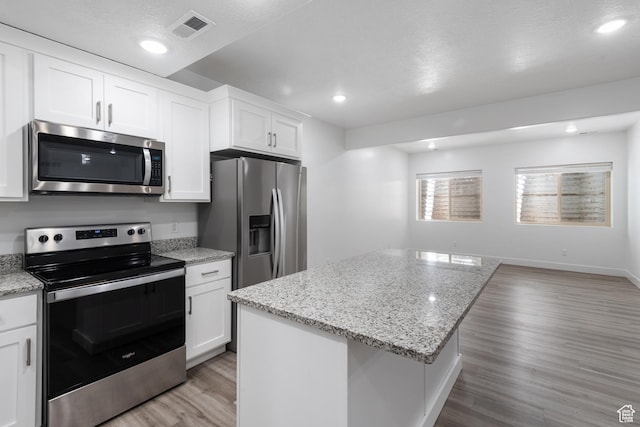 520 Lacey Way N, Salt Lake, UT 84054 - kitchen featuring stainless steel appliances, light wood-style flooring, white cabinets, a kitchen island, and light stone counters