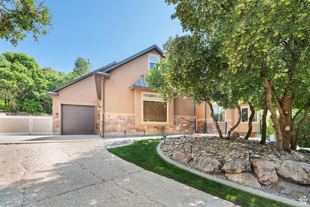520 Lacey Way N, Salt Lake, UT 84054 - view of front facade featuring stucco siding, stone siding, a garage, driveway, and a standing seam roof