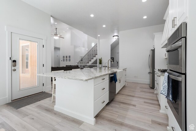520 Lacey Way N, Salt Lake, UT 84054 - kitchen with stainless steel appliances, white cabinets, a kitchen breakfast bar, recessed lighting, and a ceiling fan