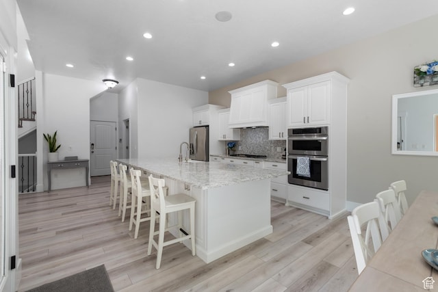 520 Lacey Way N, Salt Lake, UT 84054 - kitchen with stainless steel appliances, light wood-style floors, decorative backsplash, light stone counters, and white cabinets