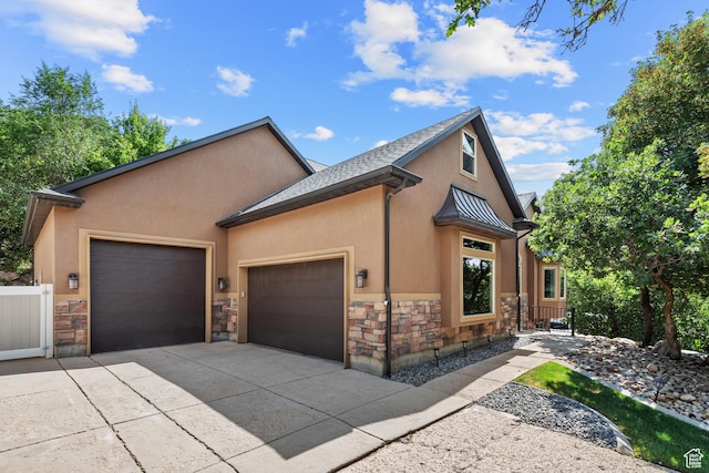 520 Lacey Way N, Salt Lake, UT 84054 - view of front facade featuring stone siding, a garage, stucco siding, and driveway