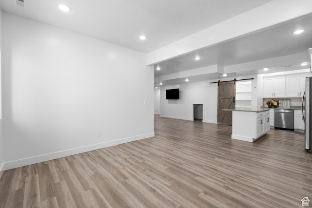520 Lacey Way N, Salt Lake, UT 84054 - unfurnished living room featuring a barn door, light wood-style floors, and recessed lighting