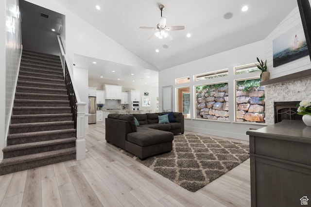 520 Lacey Way N, Salt Lake, UT 84054 - living room with high vaulted ceiling, ceiling fan, stairs, light wood-style flooring, and a stone fireplace