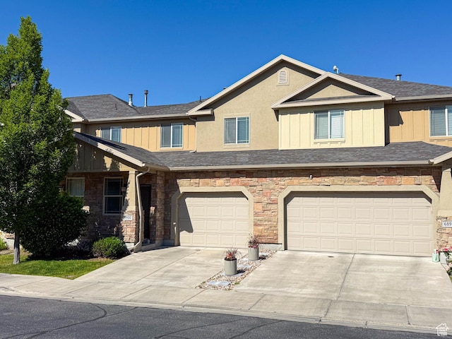 6900 S Village Haven Ln W, Midvale, UT 84047 - townhome / multi-family property featuring concrete driveway, stone siding, a garage, and board and batten siding