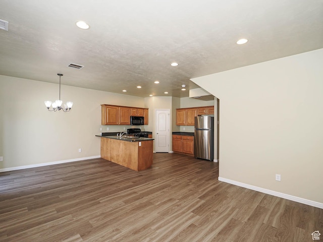 6900 S Village Haven Ln W, Midvale, UT 84047 - kitchen with black microwave, freestanding refrigerator, recessed lighting, dark countertops, and a peninsula