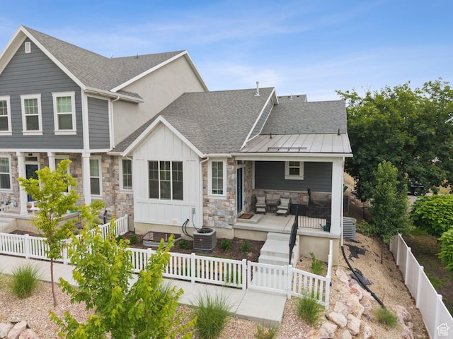 520 S Orchard Dr Unit 1, Bountiful, UT 84010 - rear view of property featuring board and batten siding, stone siding, roof with shingles, a fenced front yard, and a standing seam roof