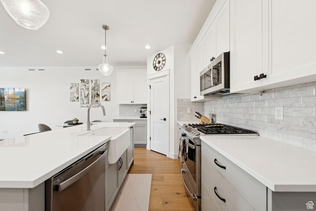 520 S Orchard Dr Unit 1, Bountiful, UT 84010 - kitchen with appliances with stainless steel finishes, light wood-type flooring, light countertops, decorative backsplash, and recessed lighting