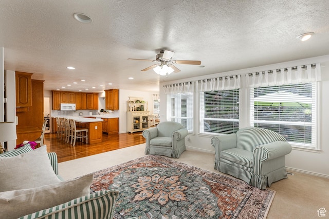 561 S Woodland Dr E, Farmington, UT 84025 - living area with healthy amount of natural light, a textured ceiling, ceiling fan, recessed lighting, and light colored carpet