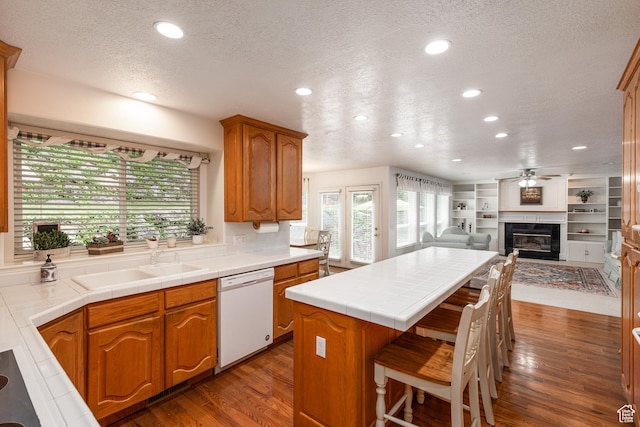 561 S Woodland Dr E, Farmington, UT 84025 - kitchen featuring white dishwasher, a textured ceiling, recessed lighting, a kitchen island, and tile countertops