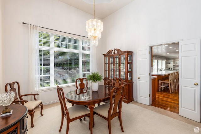 561 S Woodland Dr E, Farmington, UT 84025 - dining area featuring light colored carpet, high vaulted ceiling, and a chandelier