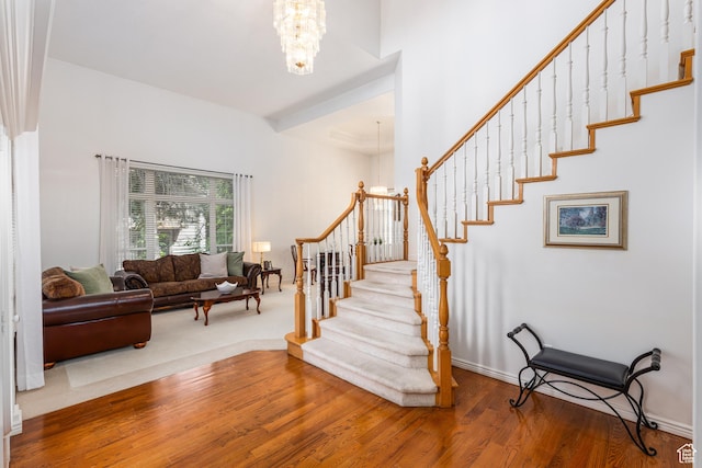 561 S Woodland Dr E, Farmington, UT 84025 - staircase featuring a chandelier, wood finished floors, and a high ceiling