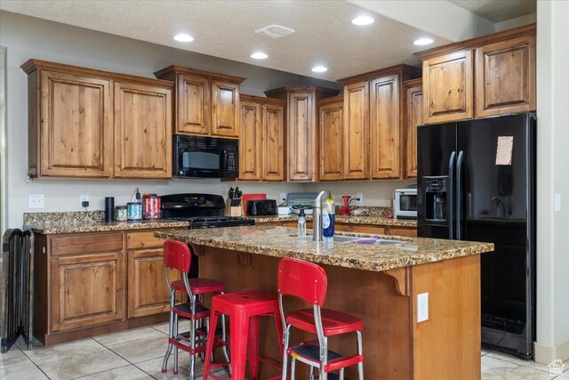 4257 W Lake Bridge Dr S, South Jordan, UT 84009 - kitchen with black appliances, brown cabinets, recessed lighting, light stone countertops, and an island with sink