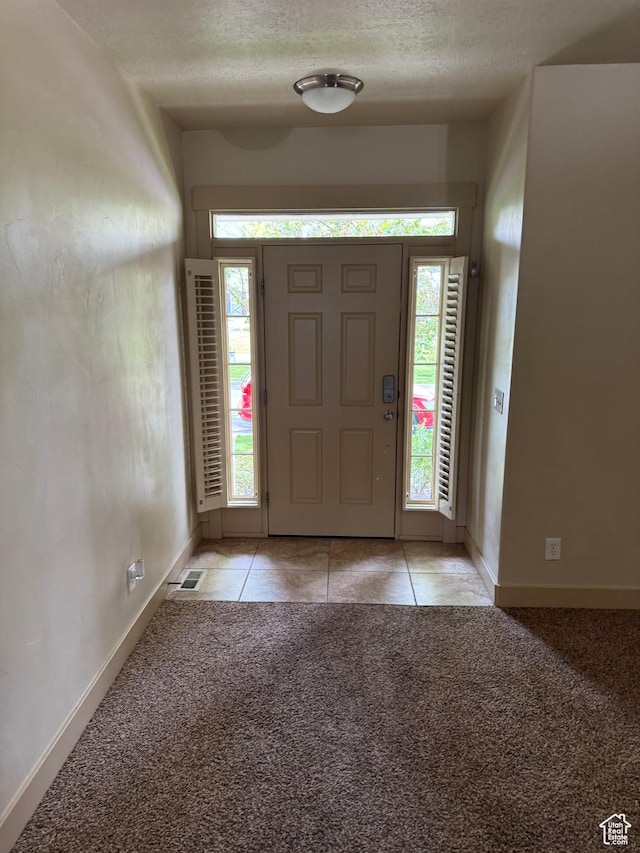4257 W Lake Bridge Dr S, South Jordan, UT 84009 - entryway featuring light carpet, light tile patterned floors, and a textured ceiling