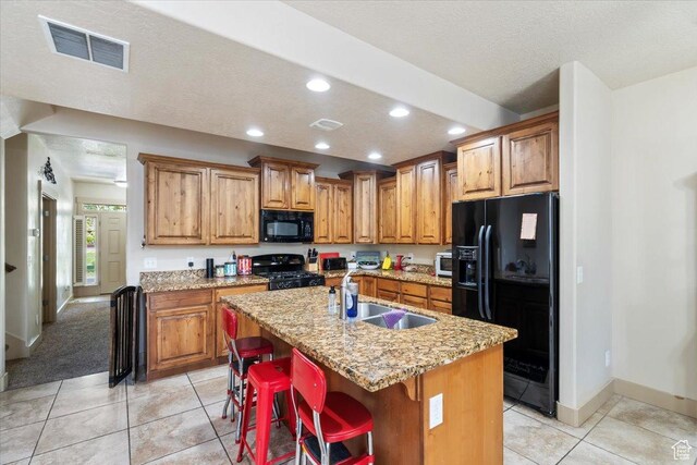 4257 W Lake Bridge Dr S, South Jordan, UT 84009 - kitchen featuring black appliances, recessed lighting, brown cabinetry, a kitchen island with sink, and a textured ceiling