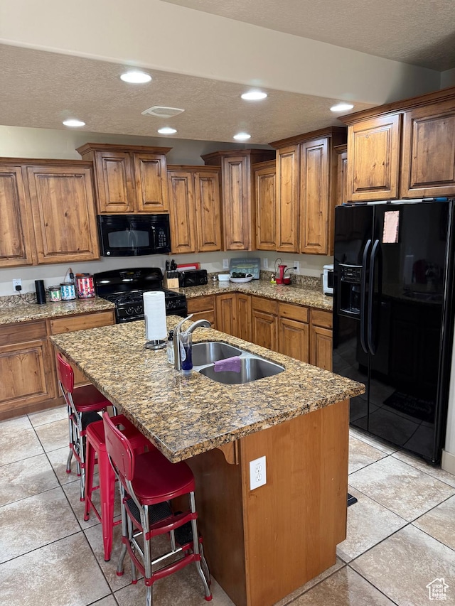 4257 W Lake Bridge Dr S, South Jordan, UT 84009 - kitchen with black appliances, brown cabinetry, light tile patterned floors, an island with sink, and recessed lighting