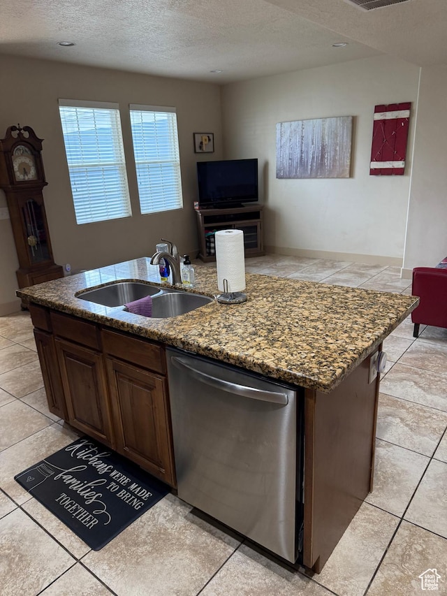 4257 W Lake Bridge Dr S, South Jordan, UT 84009 - kitchen with stainless steel dishwasher, an island with sink, a textured ceiling, dark stone countertops, and light tile patterned flooring
