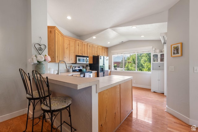 1692 E Kelmscott Ct S Unit C, Salt Lake City, UT 84124 - kitchen with appliances with stainless steel finishes, lofted ceiling, a peninsula, tile counters, and light wood finished floors