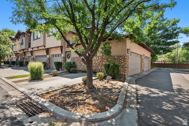 1692 E Kelmscott Ct S Unit C, Salt Lake City, UT 84124 - view of front of property featuring stone siding, stucco siding, a residential view, and a detached garage