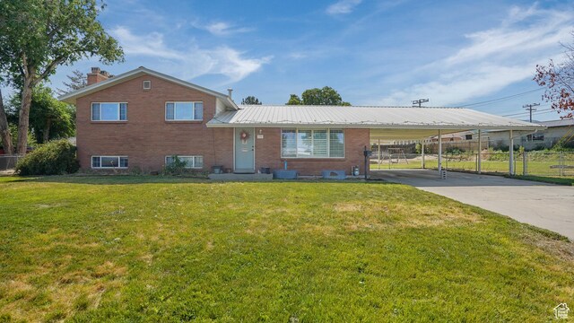 176 E Brook Ave N, Tooele, UT 84074 - split level home with brick siding, an attached carport, concrete driveway, a metal roof, and a chimney