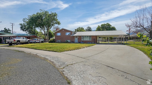 176 E Brook Ave N, Tooele, UT 84074 - tri-level home featuring driveway, a carport, brick siding, and a metal roof