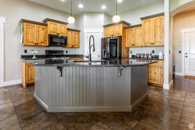 191 W Ranch Rd, Farmington, UT 84025 - kitchen featuring black microwave, refrigerator with ice dispenser, stainless steel range with gas cooktop, arched walkways, and a kitchen island with sink