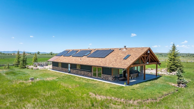 966 Mill Rd, Evanston, WY 82930 - rear view of property with stone siding, a patio, solar panels, and a lawn
