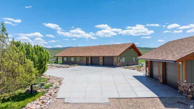 966 Mill Rd, Evanston, WY 82930 - view of front of house featuring an outdoor structure, a shingled roof, stone siding, and a detached garage