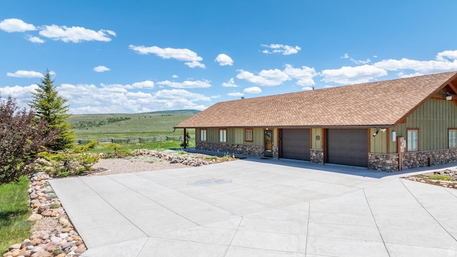 966 Mill Rd, Evanston, WY 82930 - view of front of property with board and batten siding, a garage, driveway, and stone siding