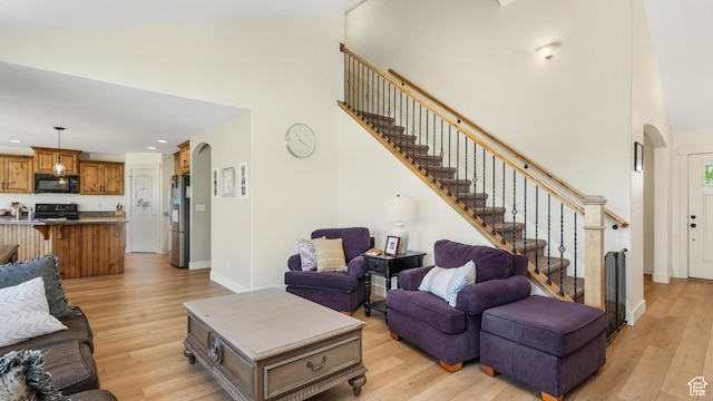 2201 W 1300 S, Lehi, UT 84043 - living room with high vaulted ceiling, stairway, arched walkways, light wood finished floors, and recessed lighting