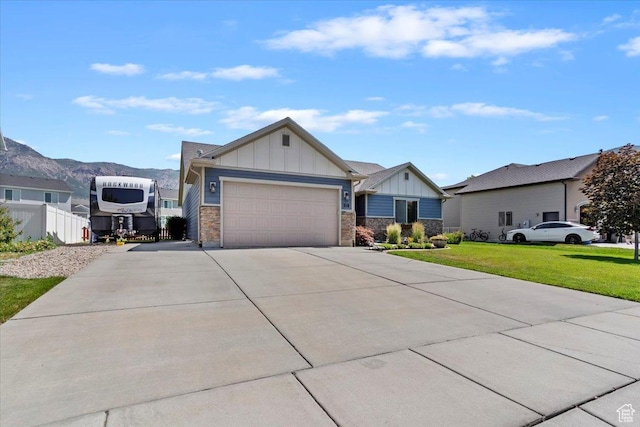 210 E 2150 N, North Ogden, UT 84414 - view of front of property featuring board and batten siding, concrete driveway, an attached garage, stone siding, and a mountain view